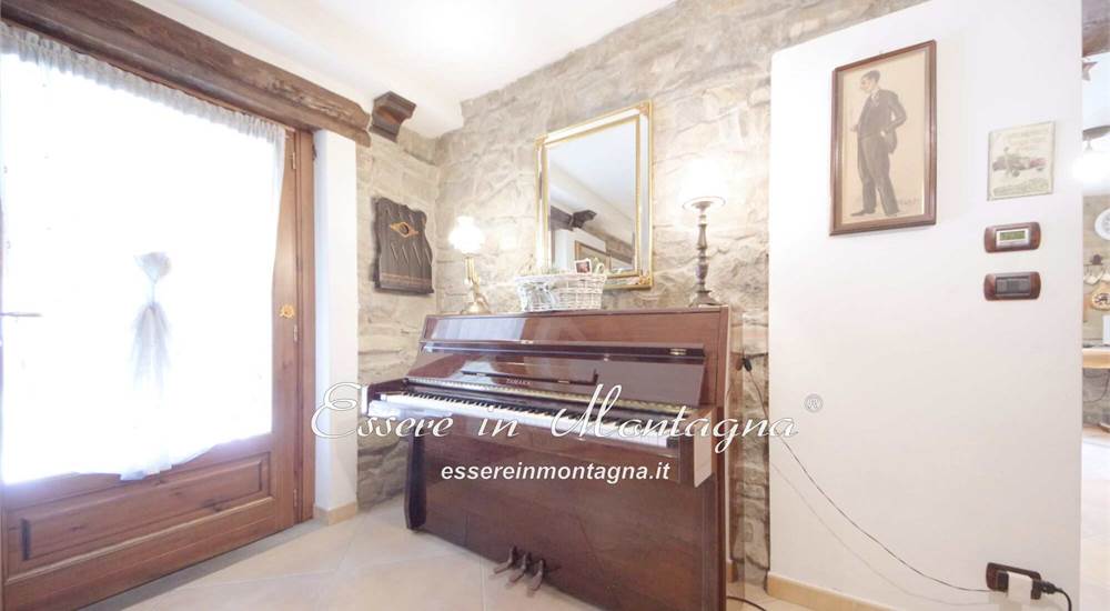 La grande sala con camino e pianoforte