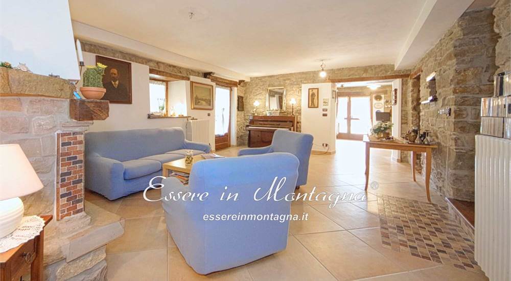 La grande sala con camino e pianoforte